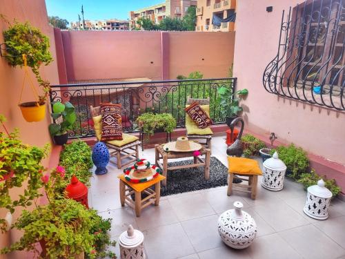 a balcony with a bunch of vases and chairs at Oranger Family House Marrakech City Center, Private Large House, Terasse Garden View, Free Parking in Marrakech