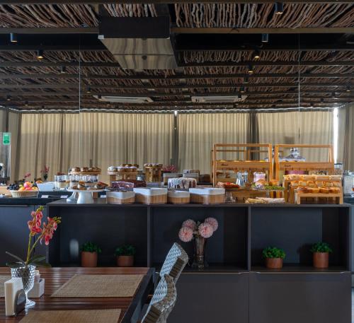 a dining room with a table and some food at Infinity at the Sea by Welkom in João Pessoa