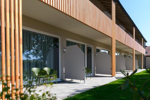 a group of chairs sitting on a patio next to a building at BERGlässig Hotel Bodenmais - 360 Grad Urlaub in Bodenmais