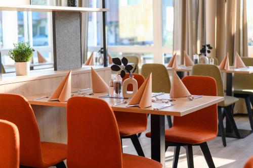 a dining room with tables and chairs with napkins on them at BERGlässig Hotel Bodenmais - 360 Grad Urlaub in Bodenmais