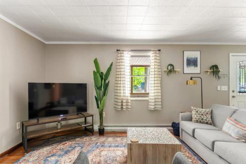 a living room with a couch and a flat screen tv at Modern decor, Hot Tub, Fire Pit, Grill, & Games in Berkeley Springs