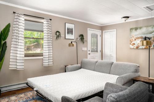 a living room with a bed and a couch at Modern decor, Hot Tub, Fire Pit, Grill, & Games in Berkeley Springs