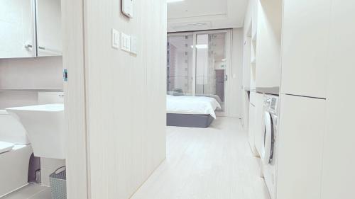 a white room with a bed and a bathroom at The Time hotel Incheon Airport in Incheon
