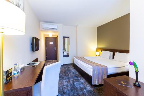 a hotel room with a bed and a desk at Golden Time Hotel in Braşov