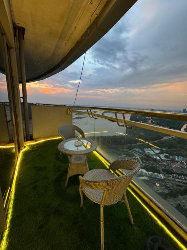 two tables and chairs on a balcony with a view at Grey Stone 41th floor river&city view in Noida