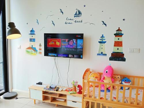 a nursery with a crib and a tv on a wall at Legoland walk 3min D'Pristine Rejoice Suite 2B2R 8pax Lakeview in Nusajaya