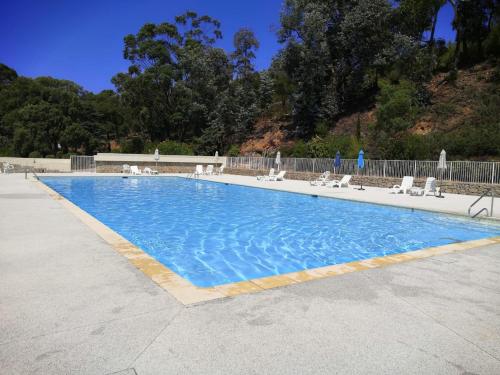 a large blue swimming pool with lounge chairs at Vue exceptionnelle in Mandelieu-la-Napoule