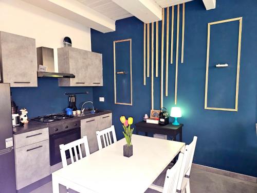 a kitchen with a white table and a blue wall at AMA Esclusive SPA Bologna in Bologna