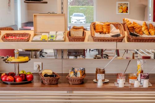 a shelf with baskets of food and baskets of bread at Ace Hotel Noyelles in Noyelles-Godault