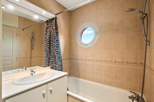 La salle de bains est pourvue d'un lavabo, d'une baignoire et d'une fenêtre. dans l'établissement T2 paisible Vaise, avec parking métro direct Bellecour, à Lyon