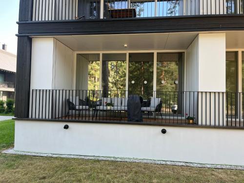 a home with a screened in porch with chairs and tables at My Marina Apartment mit Pool und Sauna am See in Bad Saarow
