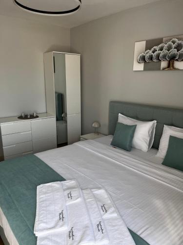 a bedroom with a large bed with white and green pillows at Apartmenthaus Oborishte 2-3-10 in Panagyurishte