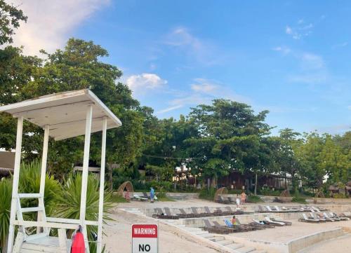 a beach with a no swimming sign and a lifeguard station at Home & Away - Luxury Condo in Mactan Newtown, Lapu-Lapu in Lapu Lapu City
