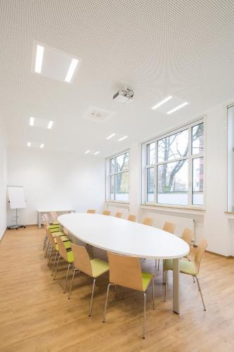 a conference room with a large white table and chairs at Hotel am alten Park in Augsburg
