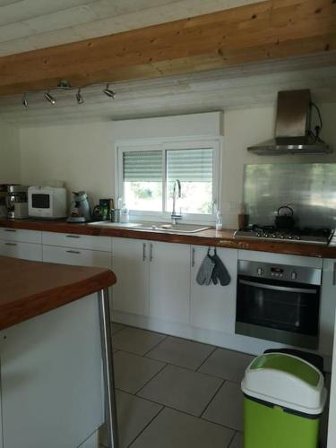 une cuisine avec un évier et une cuisinière dans l'établissement La maison vieille, à Hourtin