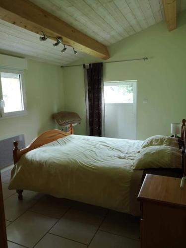 une chambre avec un lit, une table et une fenêtre dans l'établissement La maison vieille, à Hourtin