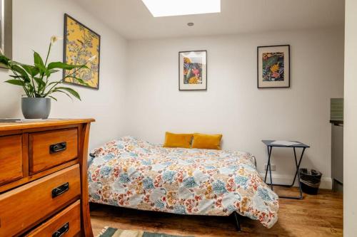 a bedroom with a bed and a dresser at Self contained two room studio apartment, own entrance, private parking in Brighton & Hove