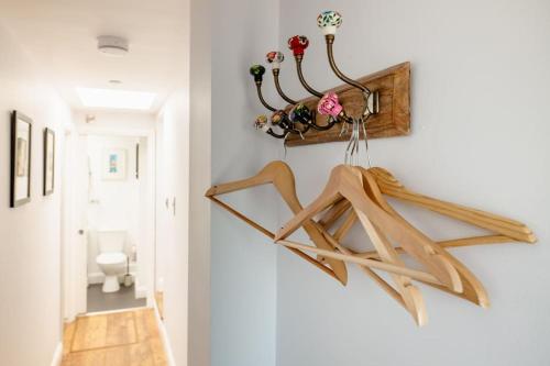 a hallway with wooden hangers on a wall at Self contained two room studio apartment, own entrance, private parking in Brighton & Hove