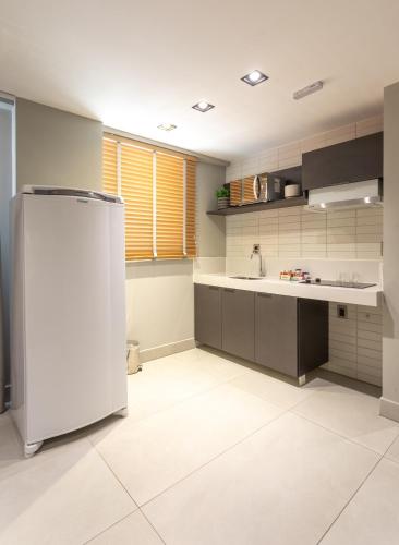 a kitchen with a refrigerator and a sink at Infinity at the Sea by Welkom in João Pessoa