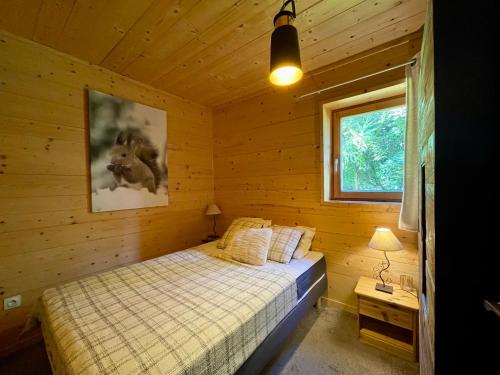 une chambre avec un lit dans une cabane en bois dans l'établissement Homency - Chalet Sagarmatha Rdc, à L'Alpe-d'Huez