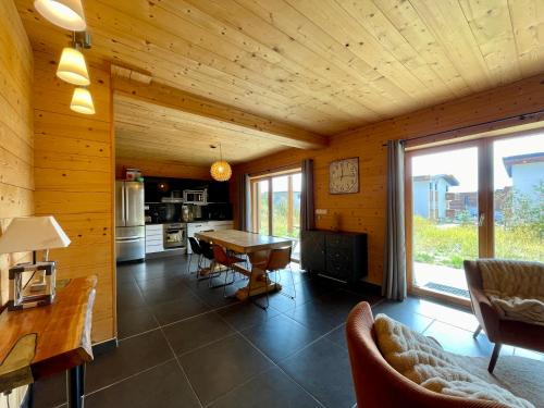 Il comprend une cuisine et une salle à manger avec un mur en bois. dans l'établissement Homency - Chalet Sagarmatha Rdc, à L'Alpe-d'Huez
