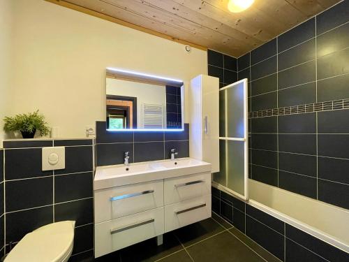 une salle de bain avec un lavabo, des toilettes et un miroir dans l'établissement Homency - Chalet Sagarmatha Rdc, à L'Alpe-d'Huez