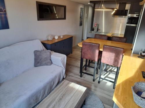 un salon avec un canapé et une table et une cuisine dans l'établissement Capri Bali 56, Superb Appart rénové, vue mer, parking, wifi, au Cap d'Agde