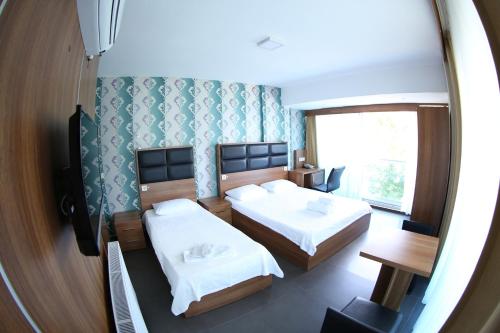 a bedroom with two beds and a mirror at Bayraktar Hotel in Akcakoca