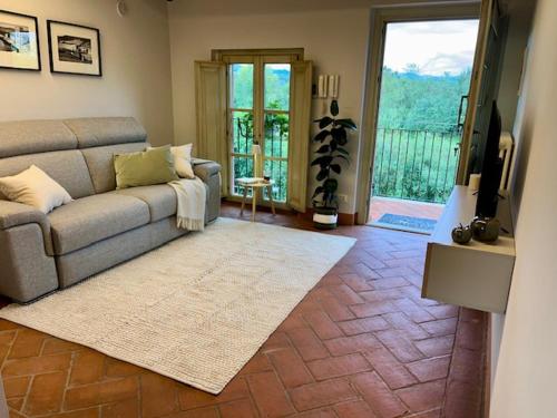 a living room with a couch and a television and a balcony at My Tuscany Relais in Altopascio