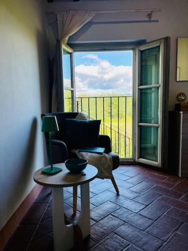 a living room with a chair and a table and a window at My Tuscany Relais in Altopascio
