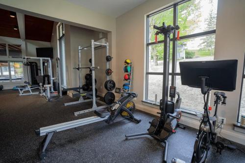 a gym with several tread machines and a window at Mount Snow Lodging in Dover