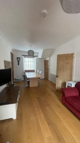a living room with a red couch and a table at Historic 3 double bed whole house by castle in Lancaster