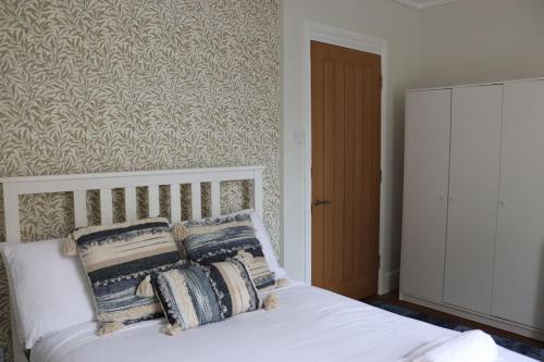 a bedroom with a white bed with pillows on it at Historic 3 double bed whole house by castle in Lancaster