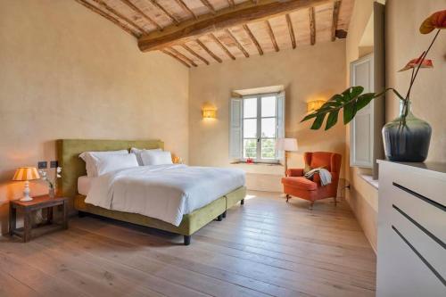 シエナにあるExclusive Villa Mamiの大きなベッドと椅子のある寝室