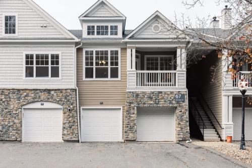 a house with two garage doors on a street at Spacious Apt with Private Balcony in Waltham