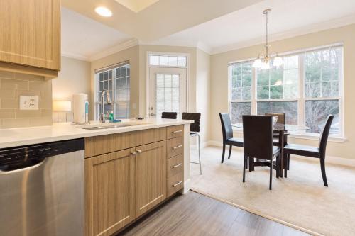 a kitchen and dining room with a table and chairs at Spacious Apt with Private Balcony in Waltham