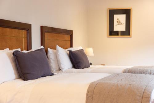 two beds in a bedroom with two pillows at Hotel Puerta del Sur in Valdivia