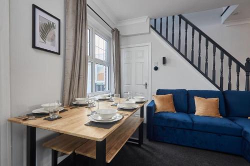 a dining room with a table and a blue couch at Cosy 3-Bedroom House in Seaham - Street Parking in Seaham