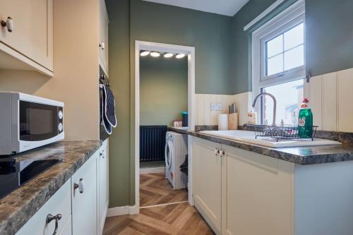 a kitchen with a sink and a microwave at Cosy 3-Bedroom House in Seaham - Street Parking in Seaham