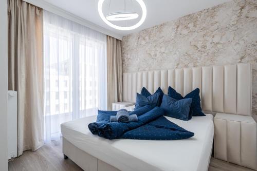 a bedroom with a bed with blue pillows on it at Corvin 5 Stars Luxury Apartment with Free Parking in Budapest