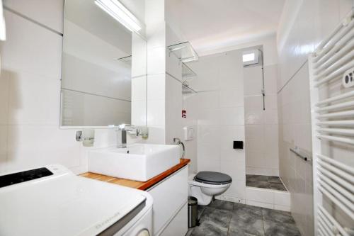une salle de bain blanche avec un lavabo et des toilettes dans l'établissement Oasis rénovée, plage, 2 parkings, wifi au Barcarès, au Barcarès