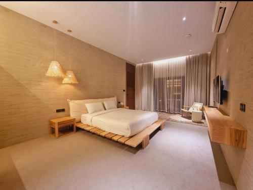 Habitación grande con cama y TV. en Valley CLIFF INN, en Al Jināh