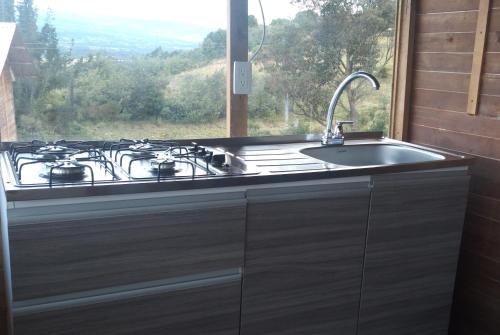 una cucina con piano cottura e lavandino con finestra di El Mirador de Juan a Guasca