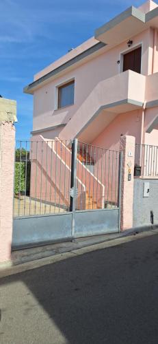 a building with a gate in front of a house at Mara casa vacanza in Maracalagonis