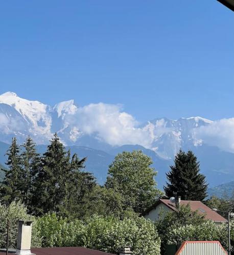 a view of snow capped mountains from a house at Charmant T2 Sallanches in Sallanches