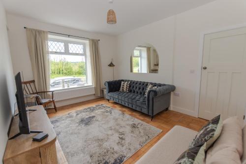 a living room with a couch and a window at Luxury Home in Penderyn - Waterfall Country in Penderyn