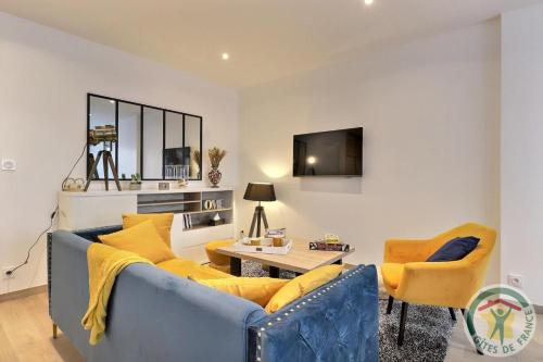 a living room with a blue couch and yellow chairs at Ker sandra in Saint-Germain-en-Coglès