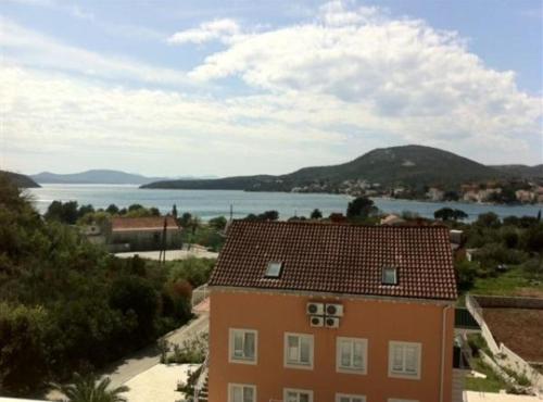 an orange building with a view of a body of water at Apartments Villa Novak in Slano