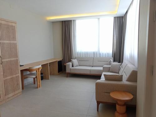 a living room with a couch and a tv at Casalita Hotel in Kizkalesi