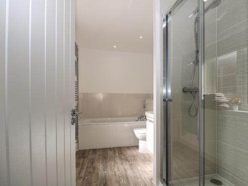 a bathroom with a tub and a toilet and a shower at Goodwood Retreat in Chichester